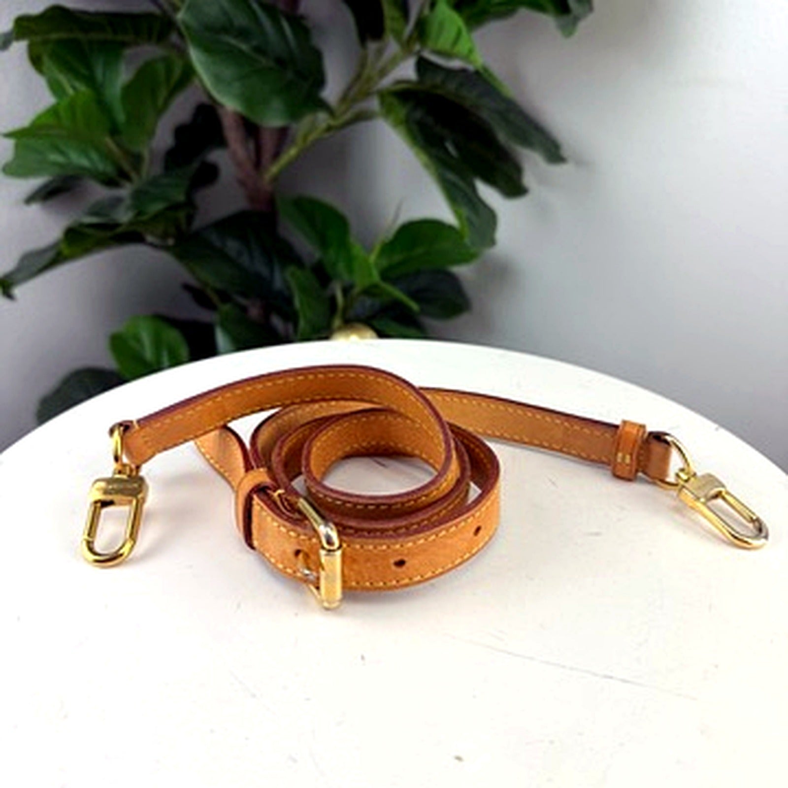 Authentic Louis Vuitton vachetta leather adjustable shoulder strap, coiled, full view