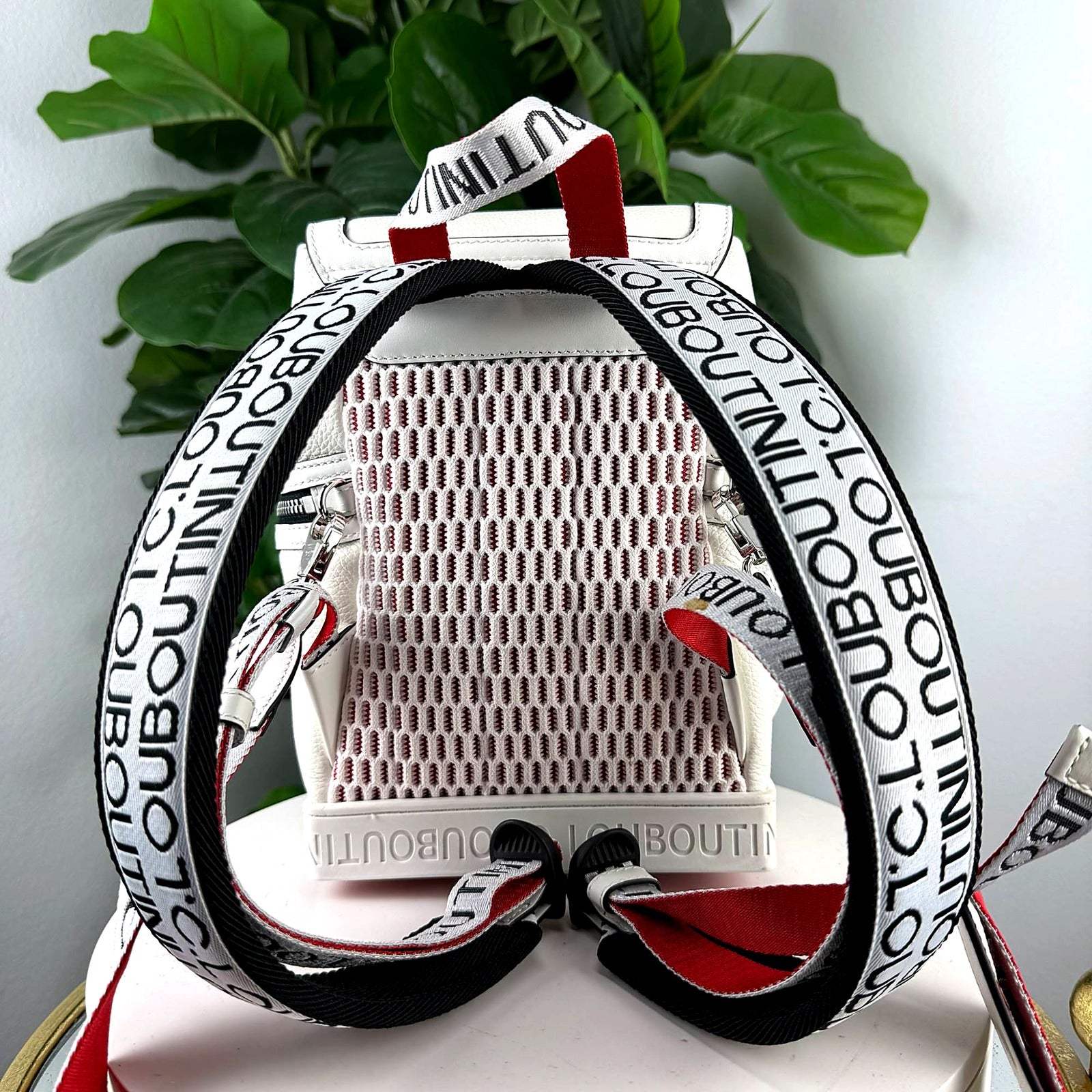Authentic Christian Louboutin white leather mini convertible backpack - back view with woven C.LOUBOUTIN strap