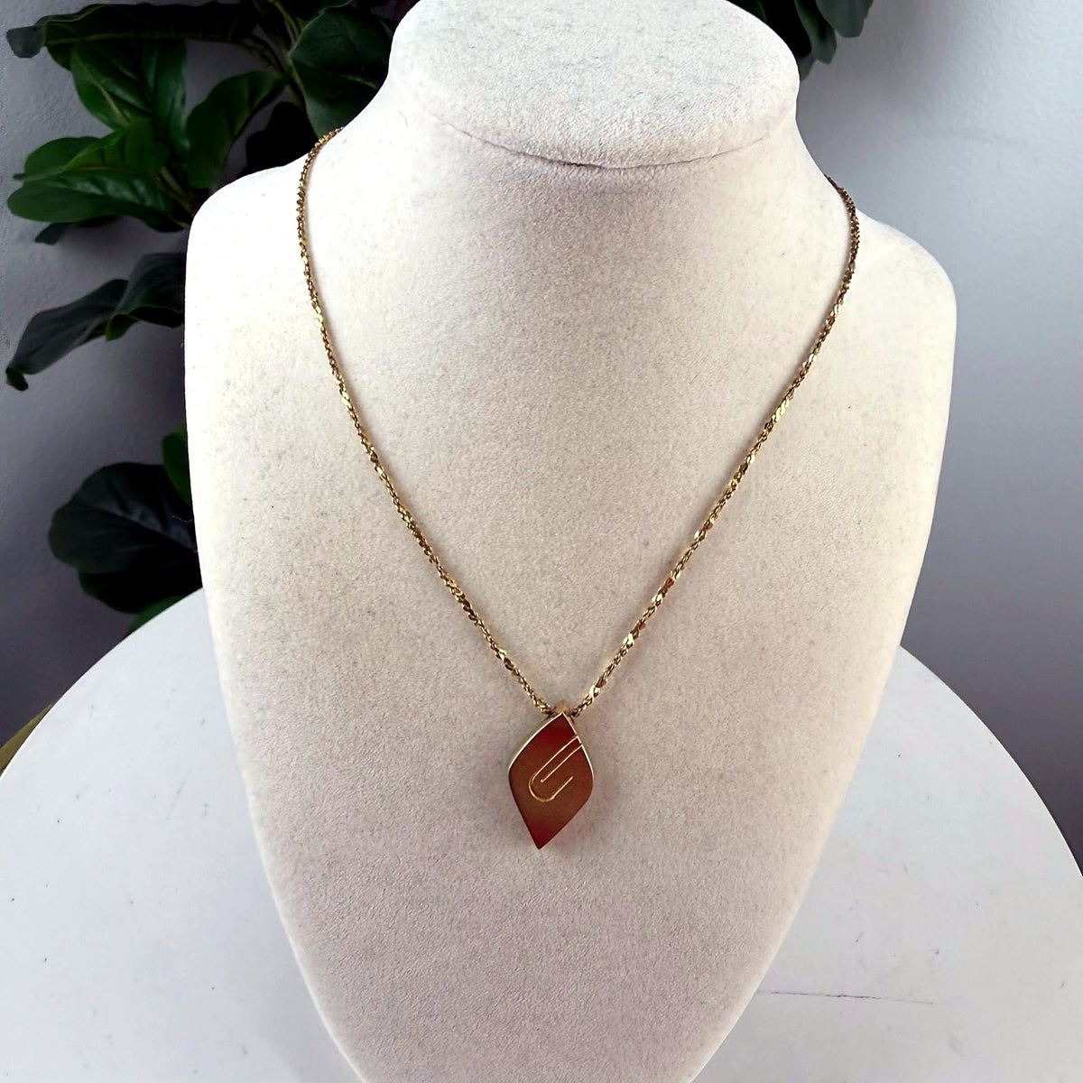Vintage gold-tone leaf pendant necklace on bust form