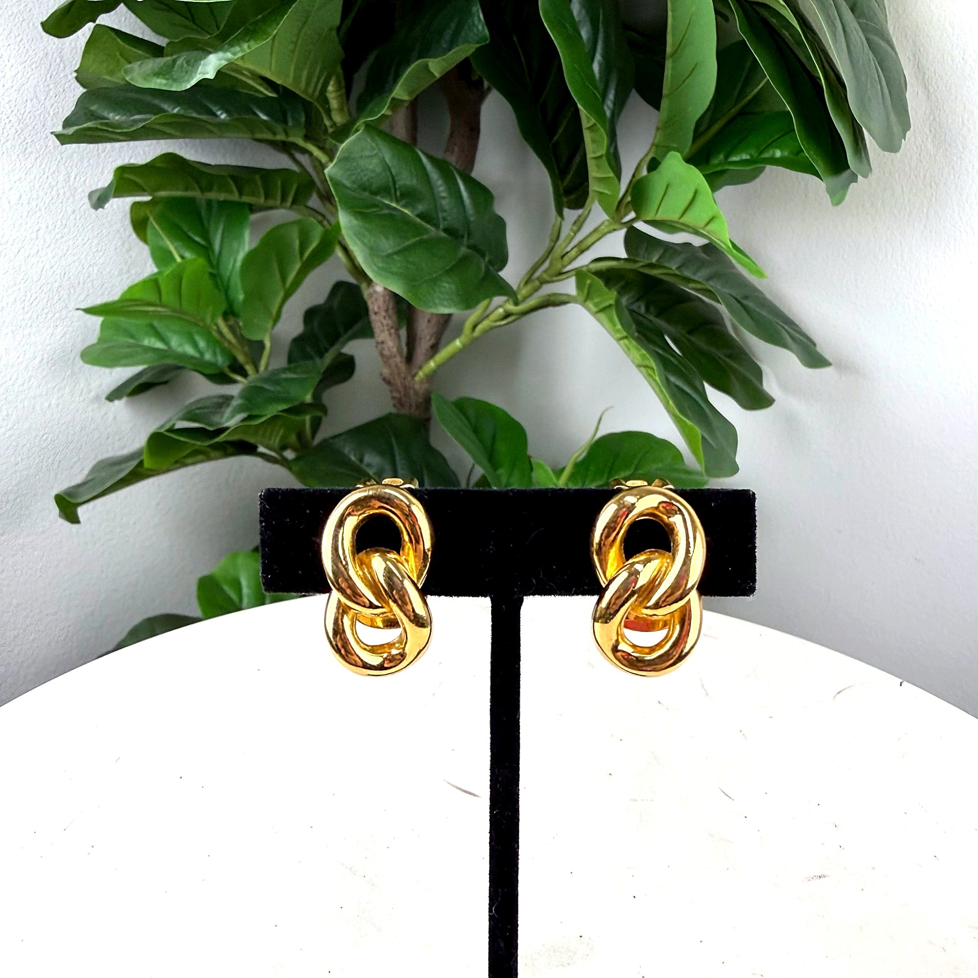Authentic Christian Dior Gold-Tone Knot Clip-On Earrings - front view on display stand