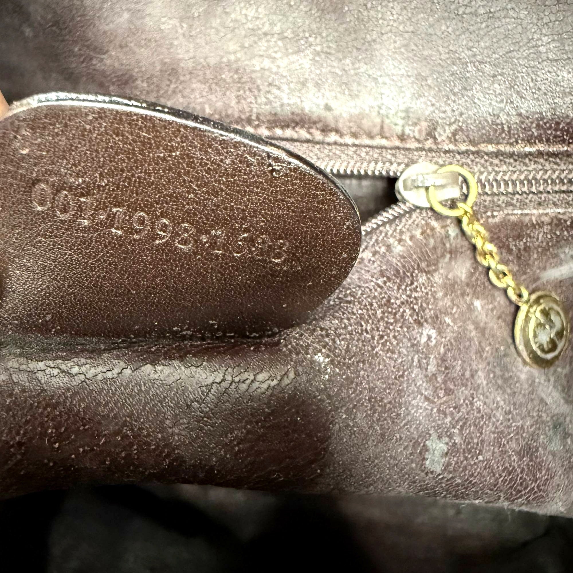 Macro shot of embossed serial number tag inside Gucci bag