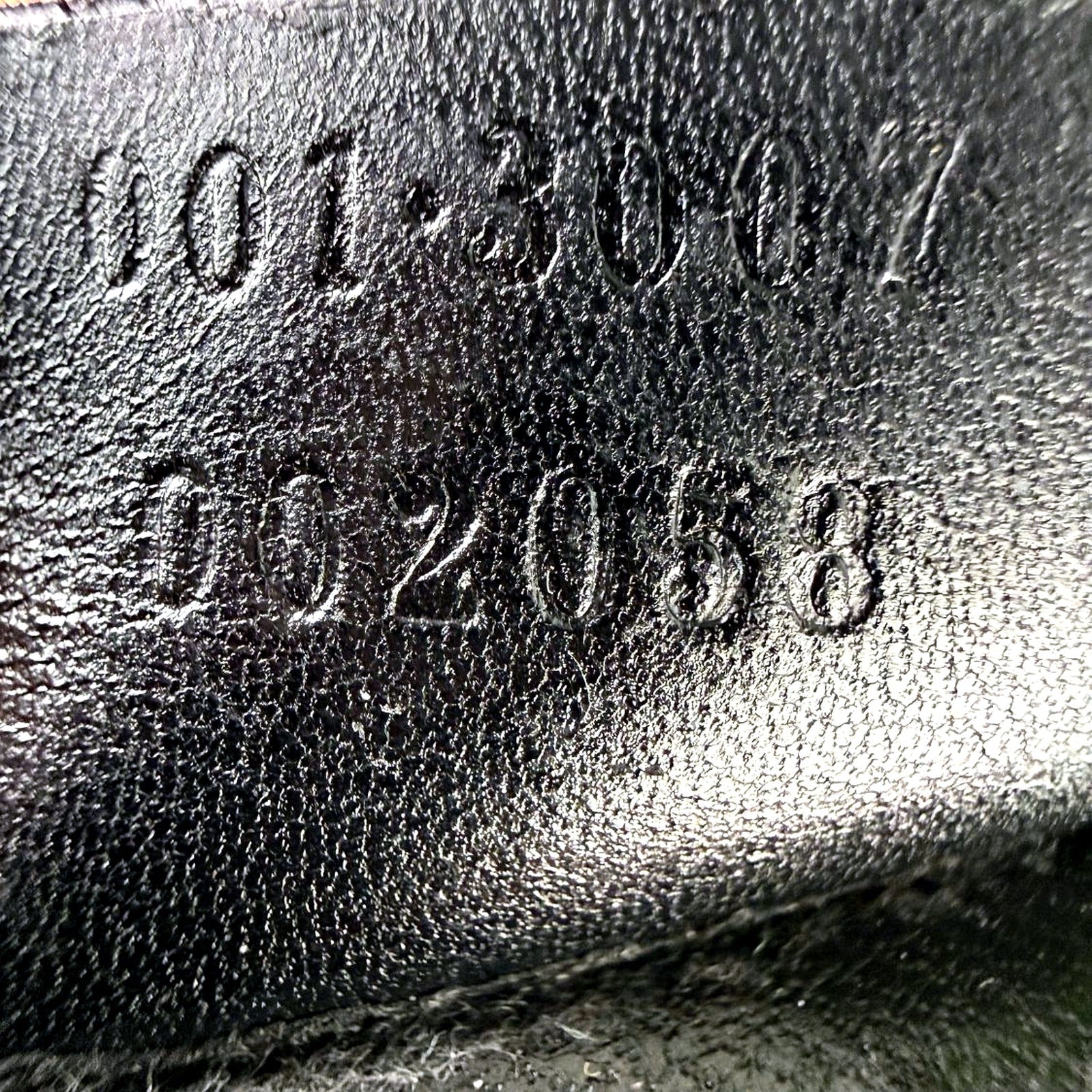 Macro shot of embossed serial number 001-3007 002058 inside Gucci bag