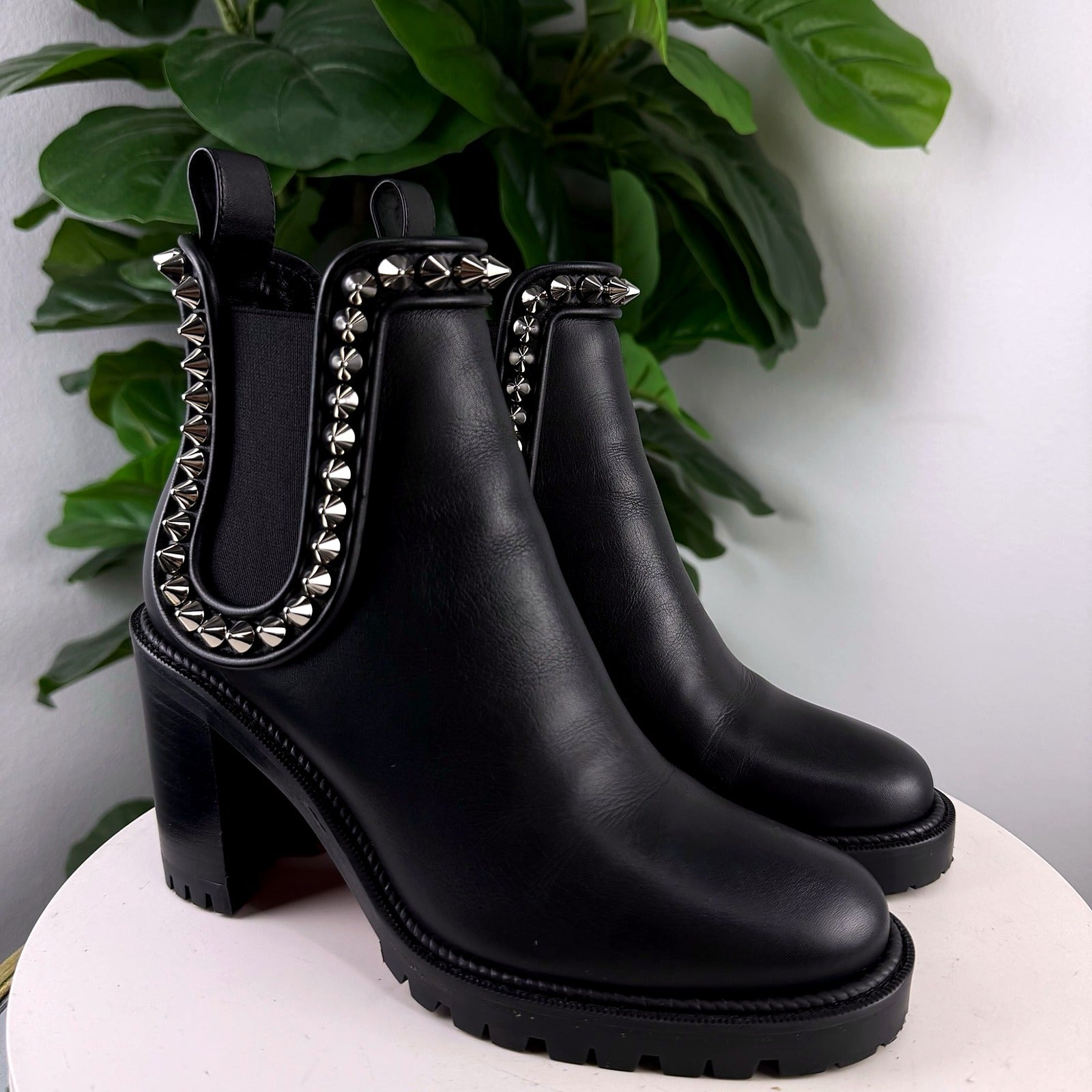 Authentic Christian Louboutin black leather spike stud ankle boots, front view of the pair