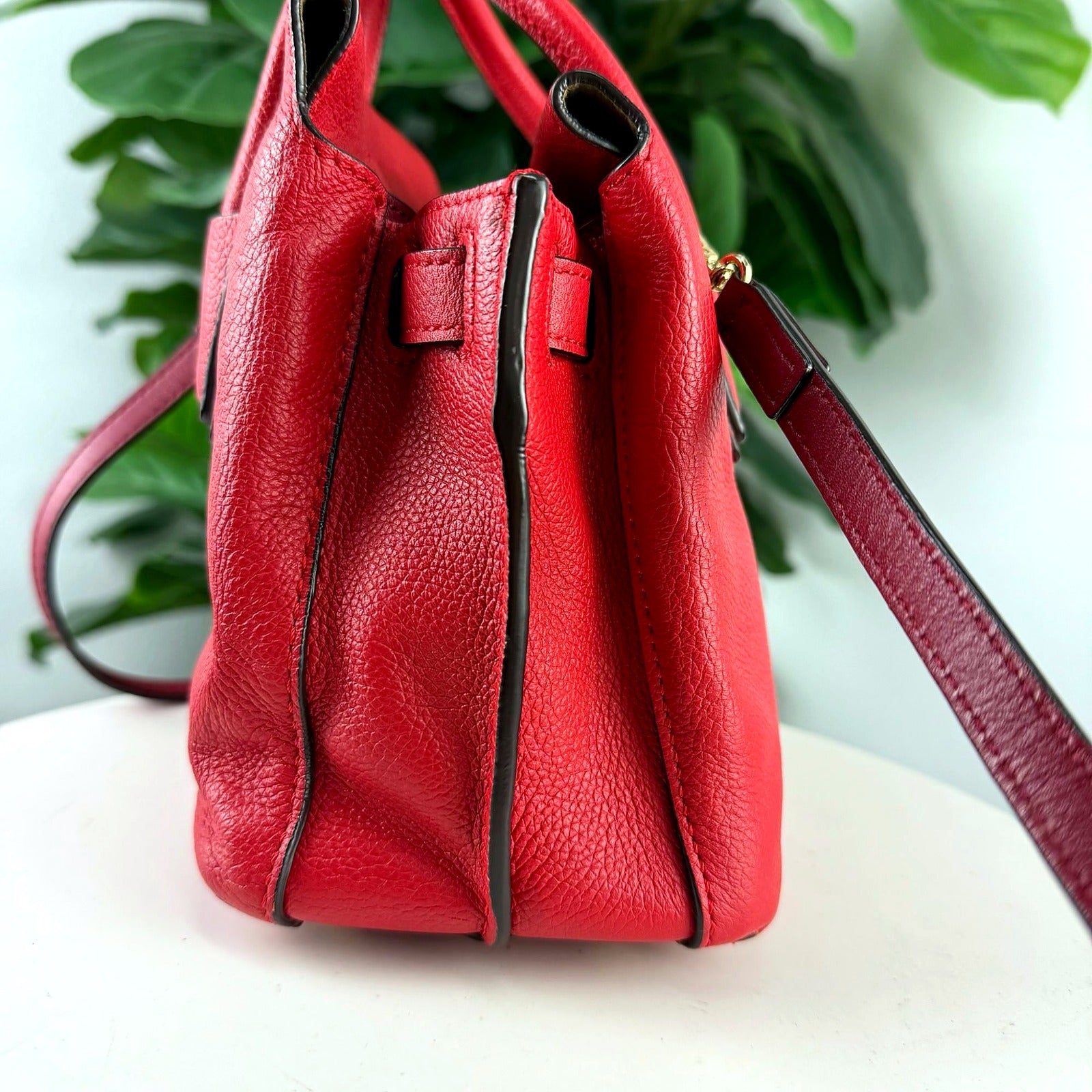 Authentic MCM red pebbled leather top handle bag - profile view showing gussets and strap