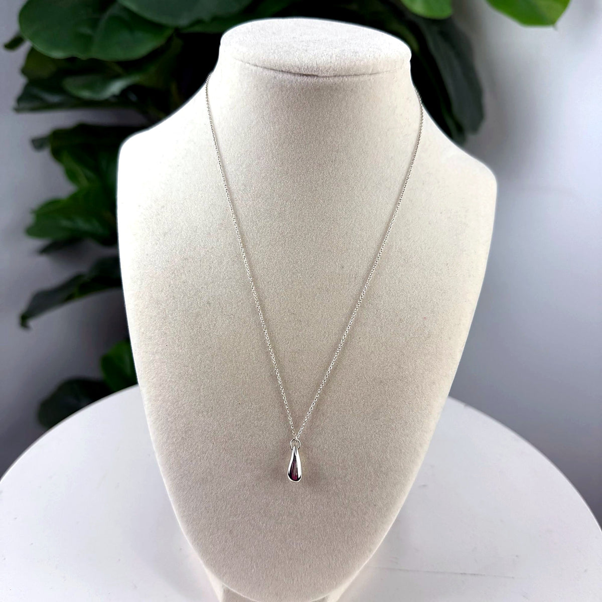Vintage silver-tone teardrop pendant necklace on bust form